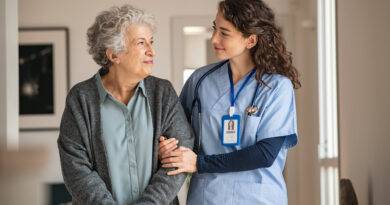 Pflegekraft unterstützt ältere Frau zu Hause