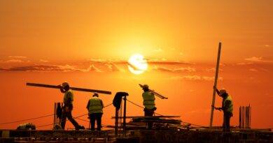 Bauarbeiter auf Baustelle bei Sonnenuntergang