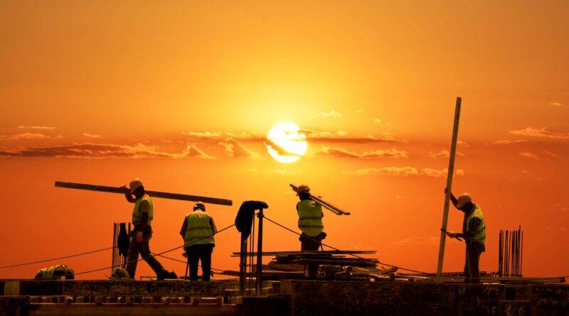 Bauarbeiter auf Baustelle bei Sonnenuntergang