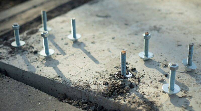 Mehrere Betonschrauben in frischem Beton montiert, Befestigung für Fundament oder Tragkonstruktion