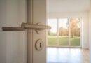Altbausanierung Berlin: Offene Tür mit Blick in einen hellen Raum mit Parkettboden und großen Fenstern nach Renovierung