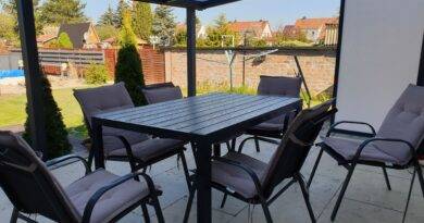 Moderne Terrassenüberdachung Berlin mit Sitzgruppe im gepflegten Garten