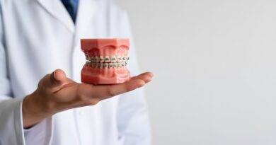 Ein Zahnarzt haelt ein Gebissmodell mit Zahnspange in der Hand – Symbol fuer moderne Kieferorthopaedie in Essen