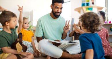 Erzieher sitzt mit Kindern im Kreis und liest vor – Symbolbild fuer Kita Assistenz und paedagogische Unterstuetzung im Kindergarten